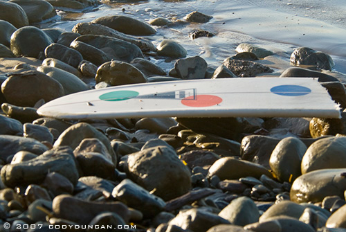 broken surfboard on rocks, rincon point