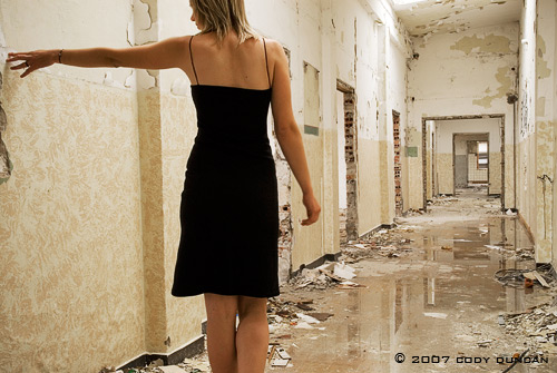 woman walking down hallway of abandoned building
