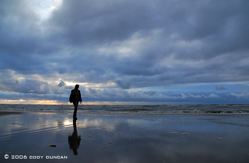 woman walking along shore of North sea at sunset on the island of Juist, Germany. © Cody Duncan photography