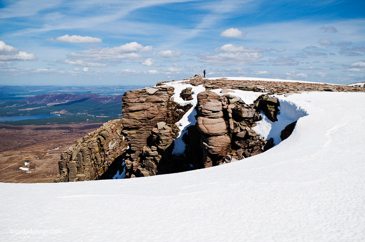 Travel stock photography: Person stands in distance on summit of Cairn Lochan in the Cairngorms, Scotland