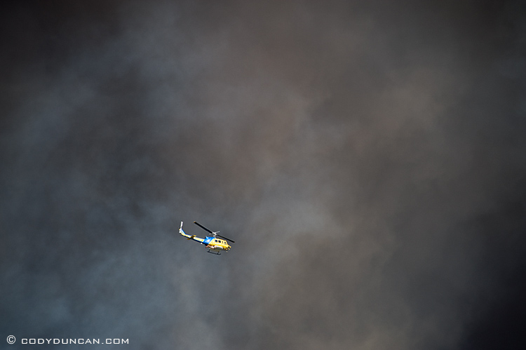 jesusita fire santa barbara, California: helicopter flies against sky black with smoke