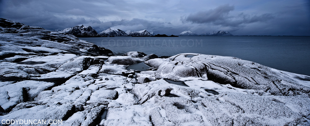 Lofoten islands panoramic landscape photography: Autumn snow covers rocky coastline