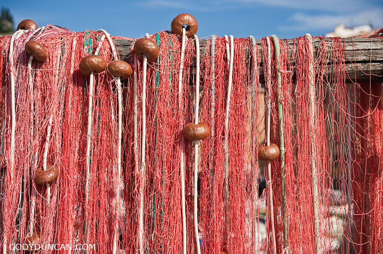 Fishing net hangs to dry in harbour, Camogli, Liguria, Italy