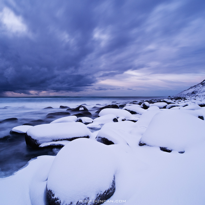 Snow covered rocks at Unstad beach, Lofoten islands, Norway