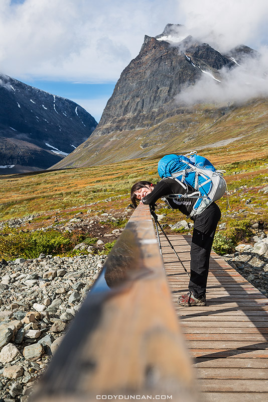 Female hiker leans on bridge in Ladtjovagge Lappland, Sweden