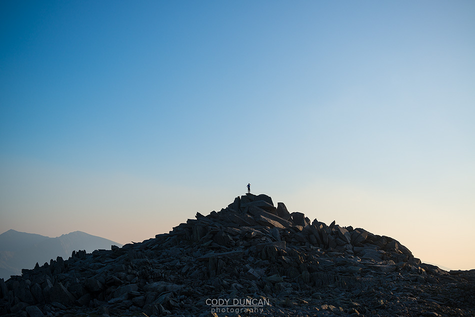 Silhouette of lone hiker on rocky summit of Glyder Fach, Snowdonia national park, Wales